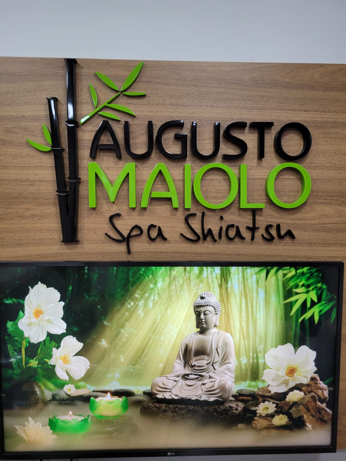 Placa de madeira Augusto Maiolo Spa Shiatsu com bambu e imagem de Buda na TV